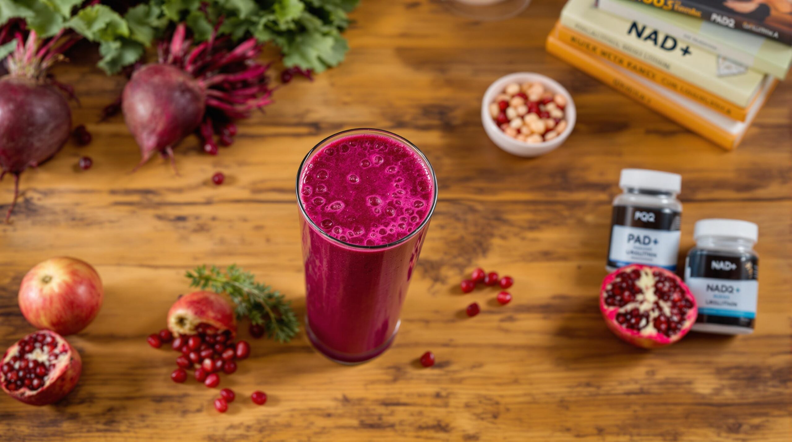 Bunte gesunde Lebensmittel wie Rote Bete, Granatapfel und Fischöl auf Küchentisch – mitochondriale Energie für aktive Best Ager.